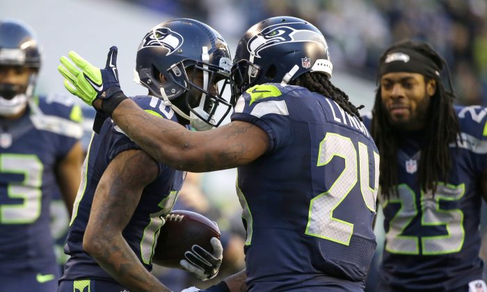 Seattle Seahawks wide receiver Paul Richardson, left, is congratulated on his first NFL touchdown by teammate Marshawn Lynch, center, as Richard Sherman looks on at right in the second half of an NFL football game against the San Francisco 49ers, Sunday, Dec. 14, 2014, in Seattle. (AP Photo/Elaine Thompson)
