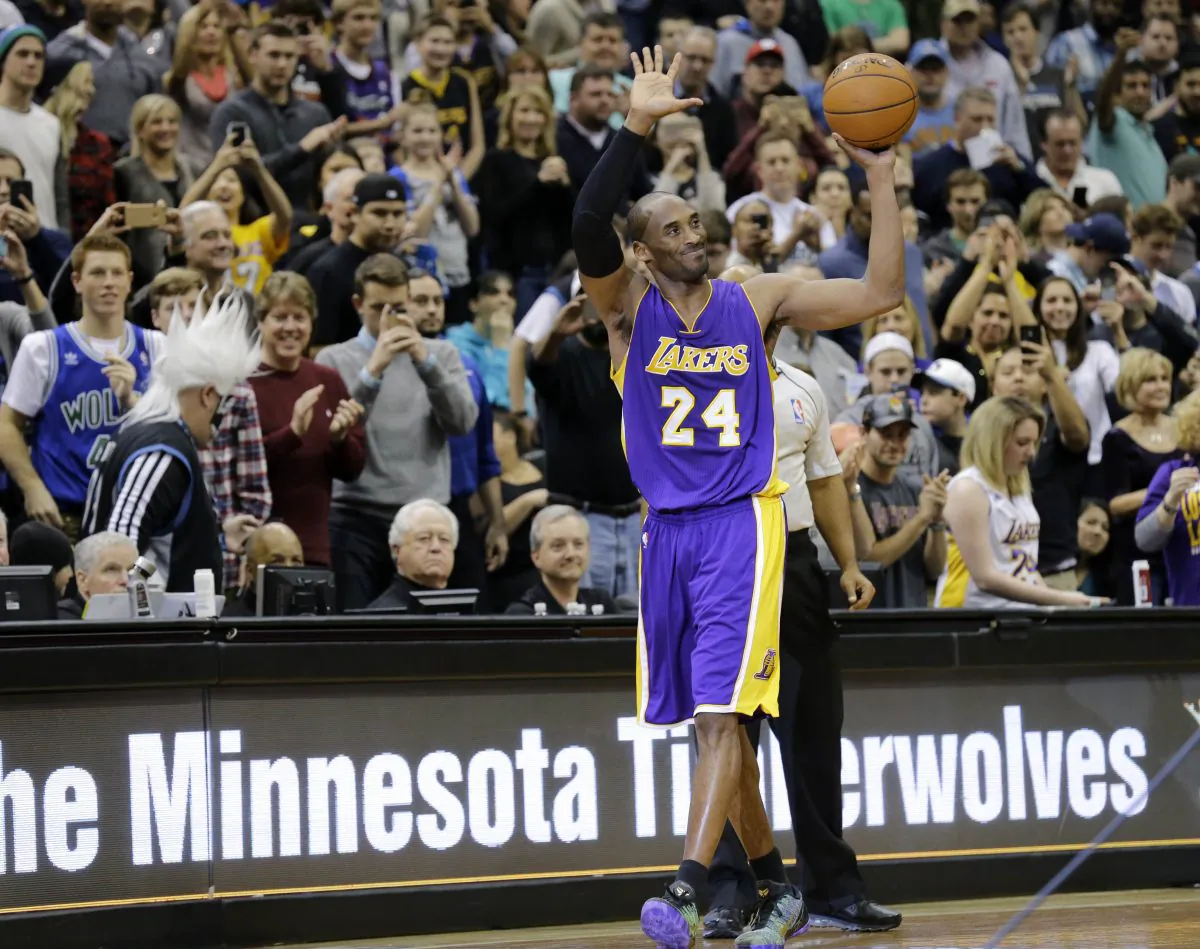 Los Angeles Lakers guard Kobe Bryant (24) holds up the game ball and acknowledges the crowd during the second quarter of an NBA basketball game against the Minnesota Timberwolves after passing Michael Jordan on the NBA all-time scoring list in Minneapolis, Sunday, Dec. 14, 2014. (AP Photo/Ann Heisenfelt)