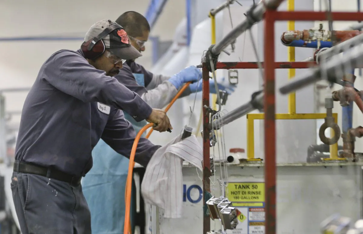 In this file photo, employees at Sheffield Platers Inc. work on the factory floor in San Diego, Calif. on Oct. 10, 2013. (AP Photo/Lenny Ignelzi)
