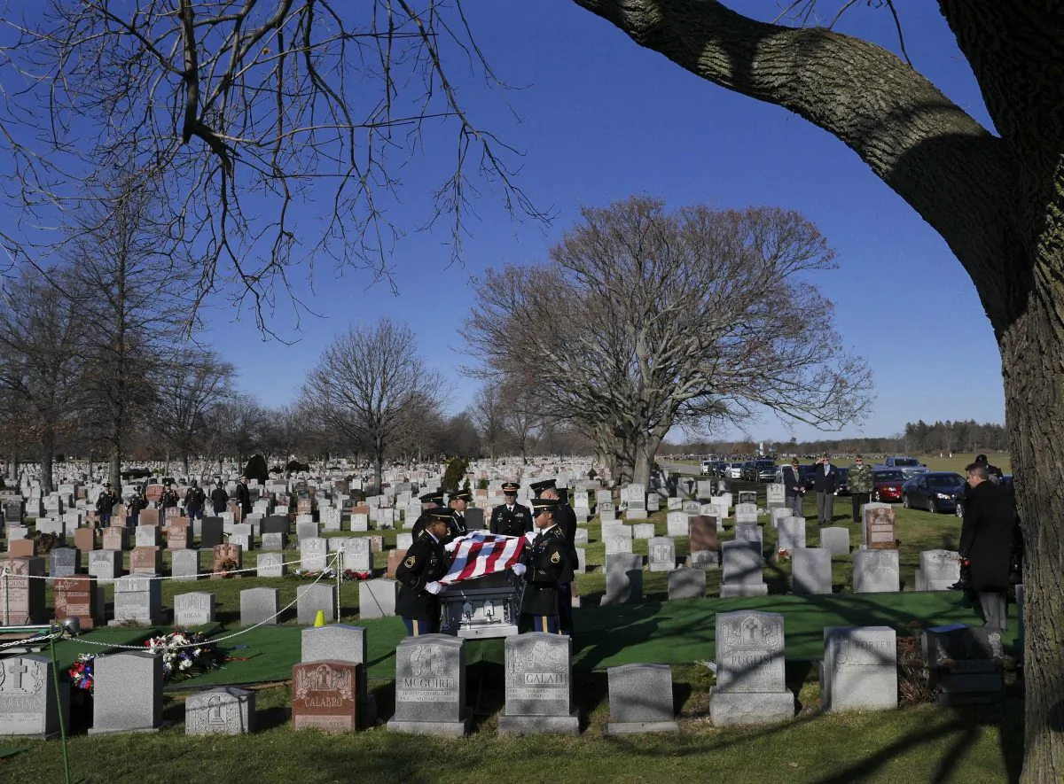 Service members fold an American flag over a casket containing the remains of Anthony La Rossa in Farmingdale, N.Y., on Monday, Dec. 15, 2014. The 18-year-old New York City soldier listed for decades as missing in action during the Korean War received full military honors at a funeral Monday on Long Island. (AP Photo/Seth Wenig)