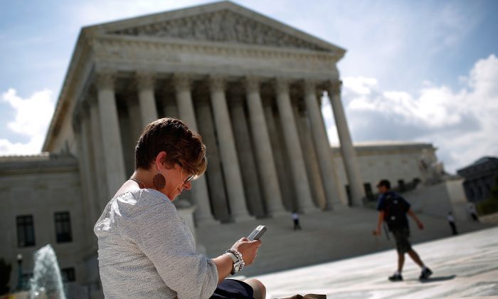 Kirsten Luna from Holland, Mich., uses her smartphone outside the U.S. Supreme Court after a major ruling on cellphone privacy by the court in Washington, D.C., on June 25, 2014. (Win McNamee/Getty Images)