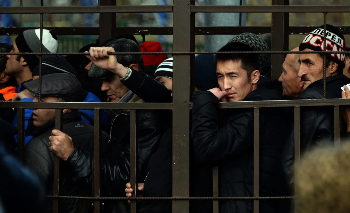 Migrant workers lining up in a fenced holding area outside Moscow’s Federal Migration Service office as they wait for their turn to get a work permit on Oct. 25, 2013. (Vasily Maximov/AFP/Getty Images)