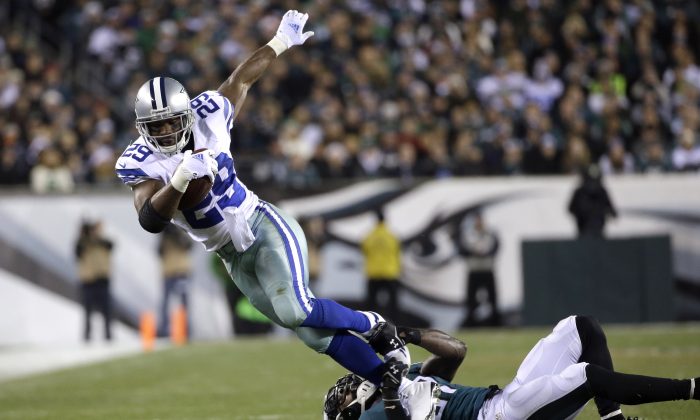 Dallas Cowboys' DeMarco Murray (29) tries to break free from a tackle by Philadelphia Eagles' Malcolm Jenkins (27) during the first half of an NFL football game, Sunday, Dec. 14, 2014, in Philadelphia. (AP Photo/Michael Perez)