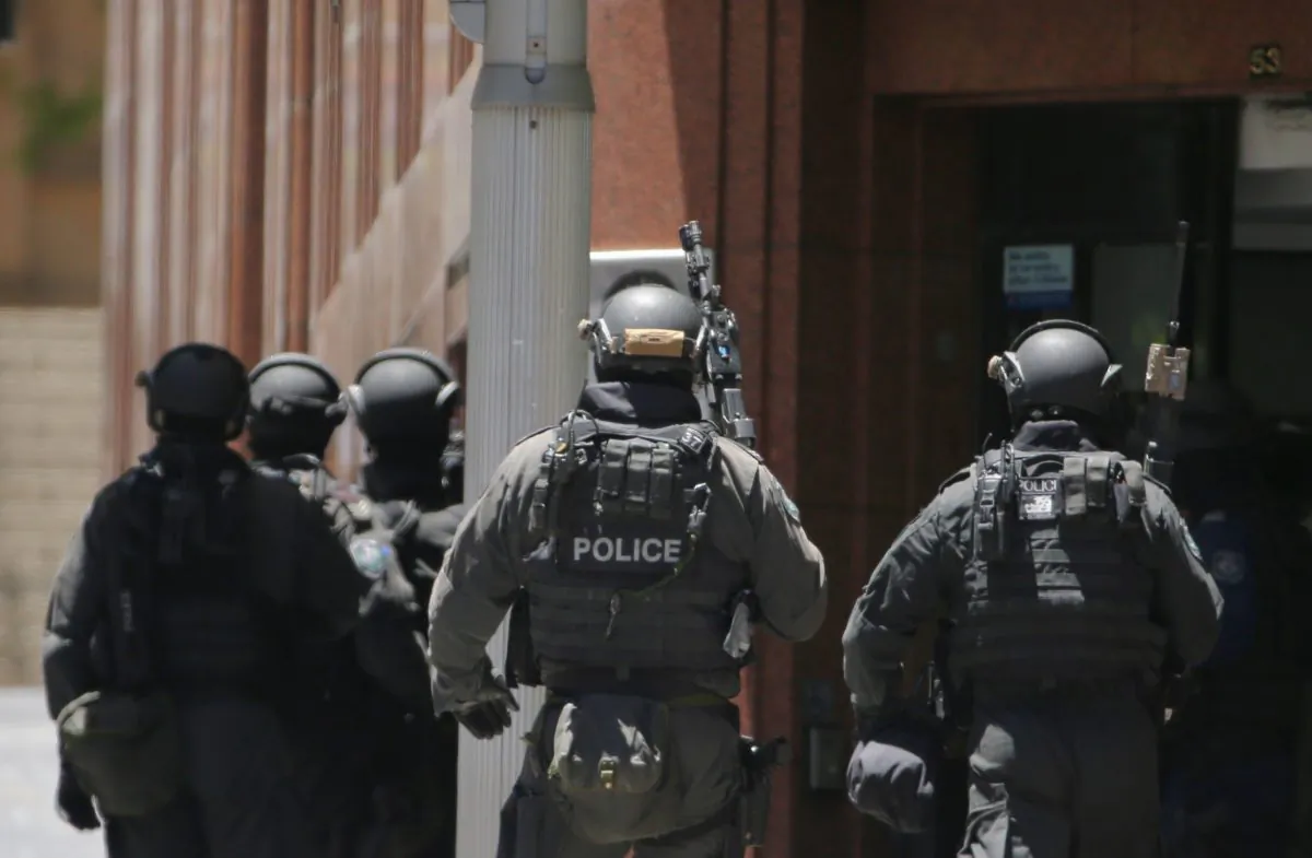 Armed police stand at the ready close to a cafe under siege at Martin Place in Sydney, Australia, Monday, Dec. 15, 2014. (AP Photo/Rob Griffith)