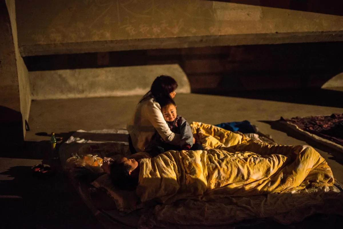 A mother hugs her child in a temporary shelter in Ya'an, southwest China's Sichuan province, after an earthquake on April 21, 2013.
A mother and her 10 month-old boy were rescued by police after being illegally detained for five days in a hotel by local Family Planning Office in Tuanlin town in Linxi City of eastern China’s Shandong Province, on Nov. 25, 2014. (STR/AFP/Getty Images)