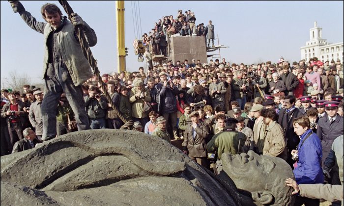 A Romanian worker stands atop the statue, sculptured in a pure style of socialist realism, of Russian Bolshevik revolutionary leader Vladimir Ilyich Lenin after it was removed from its pedestal on March 5, 1990, in Bucharest. Romanian communist dictator Nicolae Ceausescu and his wife Elena were executed by firing squad on Dec. 25, 1989, in Bucharest after being found guilty by an army tribunal of 'crimes against the people'. (Andre Durand/AFP/Getty Images)