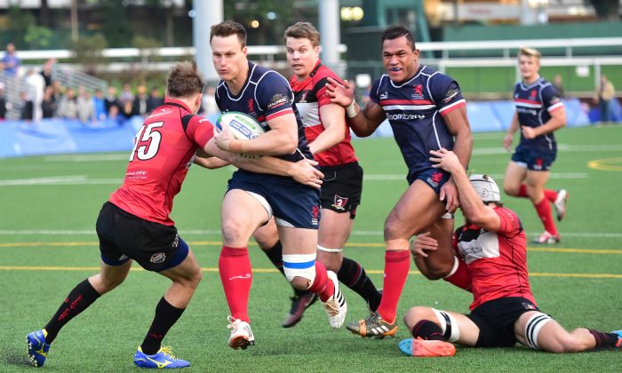 Bryan Rennie brushes past the Societe Generale Valley defence to score a try for Bloomberg HK Scottish in their Premiership match at Valley-8 on Saturday Dec. 13, 2014. (Bill Cox/Epoch Times) 