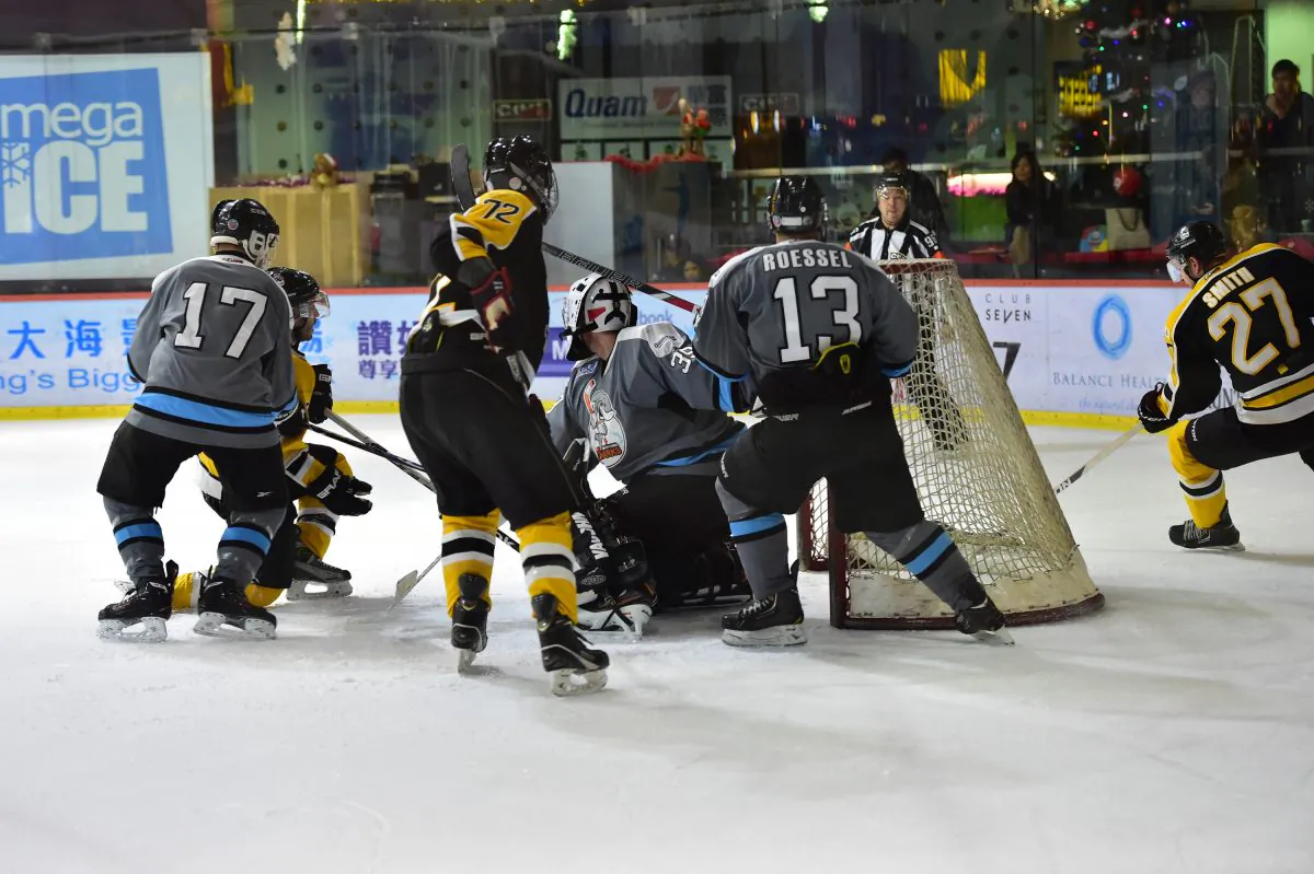 Predator Brad Smith for the Hong Kong Tycoons takes the puck around the net to find a way into goal during their CIHL Match against South China Sharks at Mega Ice on Saturday Dec 13. (Bill Cox/Epoch Times)