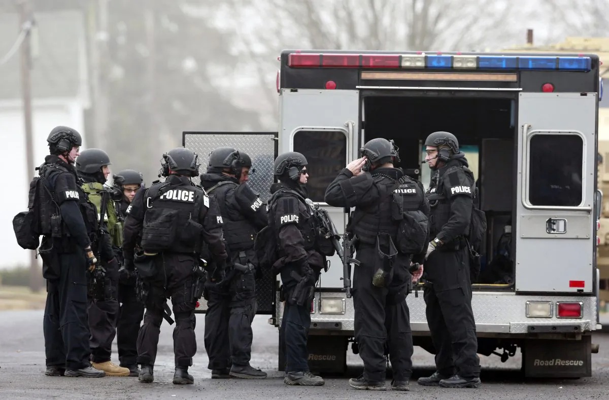 Police make preparations at a staging area for the search for suspect Bradley William Stone, Tuesday, Dec. 16, 2014, in Pennsburg, Pa. The manhunt for the Marine veteran suspected of killing his ex-wife and five of her relatives, amid a child custody dispute, has spread to two suburban Philadelphia counties. (AP Photo/Matt Rourke)