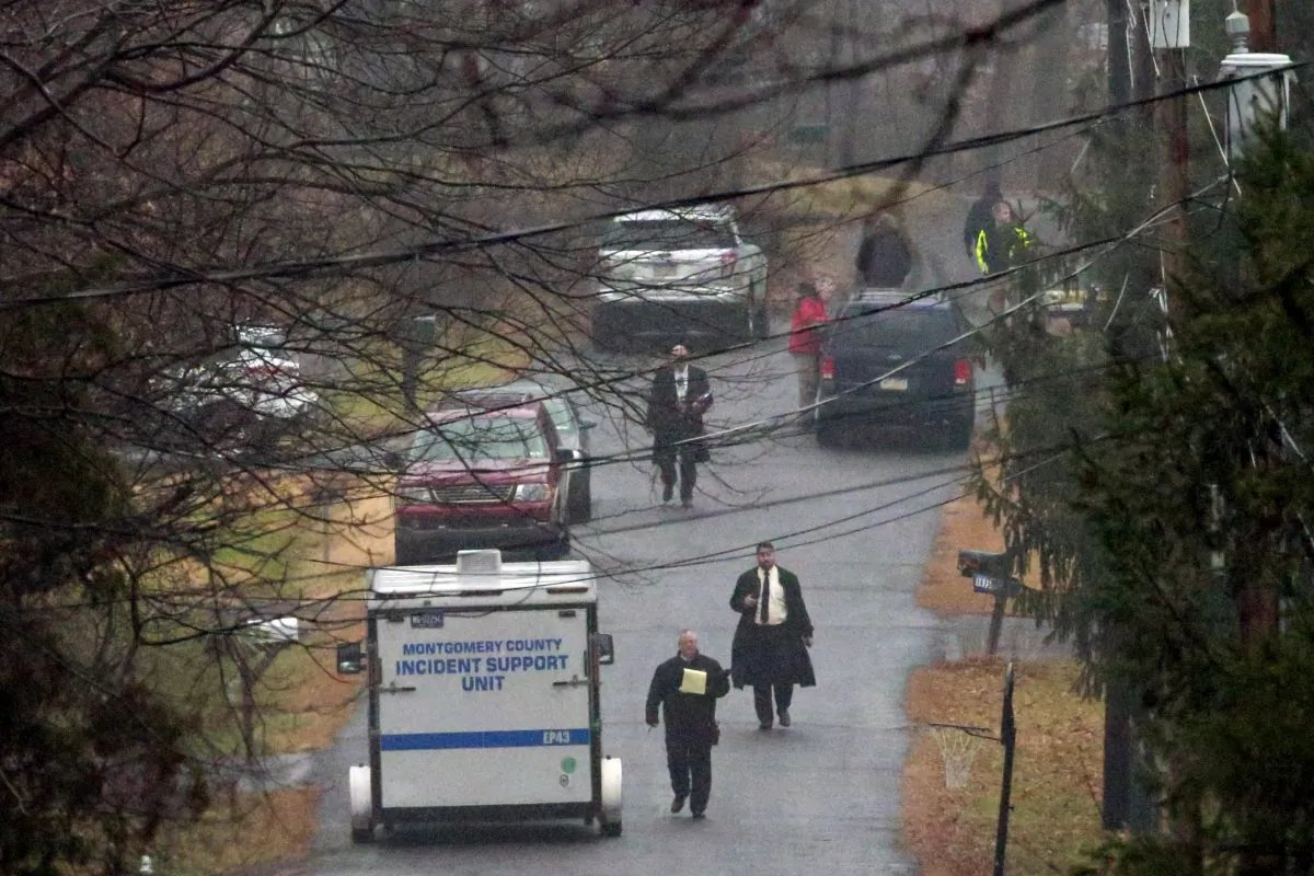 Investigators work in a wooded area near where an unidentified body was discovered during a search for suspect Bradley William Stone, Tuesday, Dec. 16, 2014, in Pennsburg, Pa. Police searching for the ex-Marine suspected of killing his ex-wife and five of her relatives discovered a body in the woods near his suburban Philadelphia home Tuesday on the second day of a manhunt that closed schools and prompted increased security at veterans hospitals and other facilities. (AP Photo/Matt Rourke)