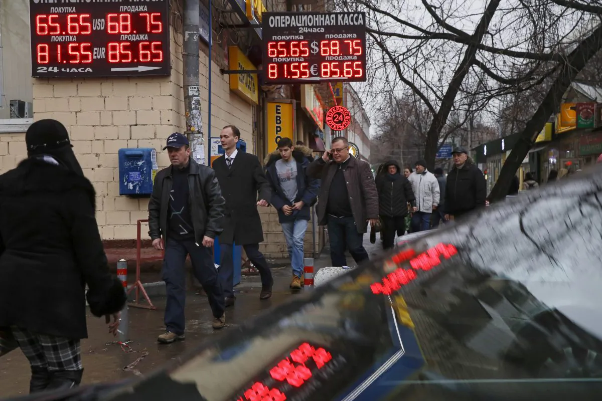 Signs advertising currencies are illuminated next to the exchange office in Moscow, Russia, Tuesday, Dec. 16, 2014. After a massive overnight rate hike by Russia's Central Bank, the ruble staged a two-hour rally Tuesday morning before rolling back to new historic lows. The surprise Central Bank decision to raise the rate to 17 percent from 10.5 percent came in the early hours on Tuesday in a desperate attempt to prop up the troubled currency. It's the biggest interest rate hike since 1998, the year when Russia defaulted on its sovereign bonds. (AP Photo/Pavel Golovkin)
