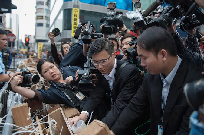 Court bailiffs post a copy of the injunction order on Argyle Street in Mongkok district on November 19, 2014 in Hong Kong. Chiu Luen Public Light Bus Company obtained the injunction for Argyle Street and it was published on newspaper to notify the occupiers. (Anthony Kwan/Getty Images)