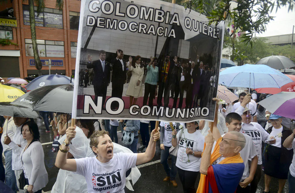 People attend the 'Peace without Impunity' march, against the current peace talks with FARC rebels in Medellin, a sign reads 'Colombia wants democracy, not communism', Antioquia department, on Dec. 13, 2014. Hundreds of people marched Saturday in several cities in Colombia to question the peace negotiations between the government of President Juan Manuel Santos and the FARC guerrillas. (Raul Arboleda/AFP/Getty Images)