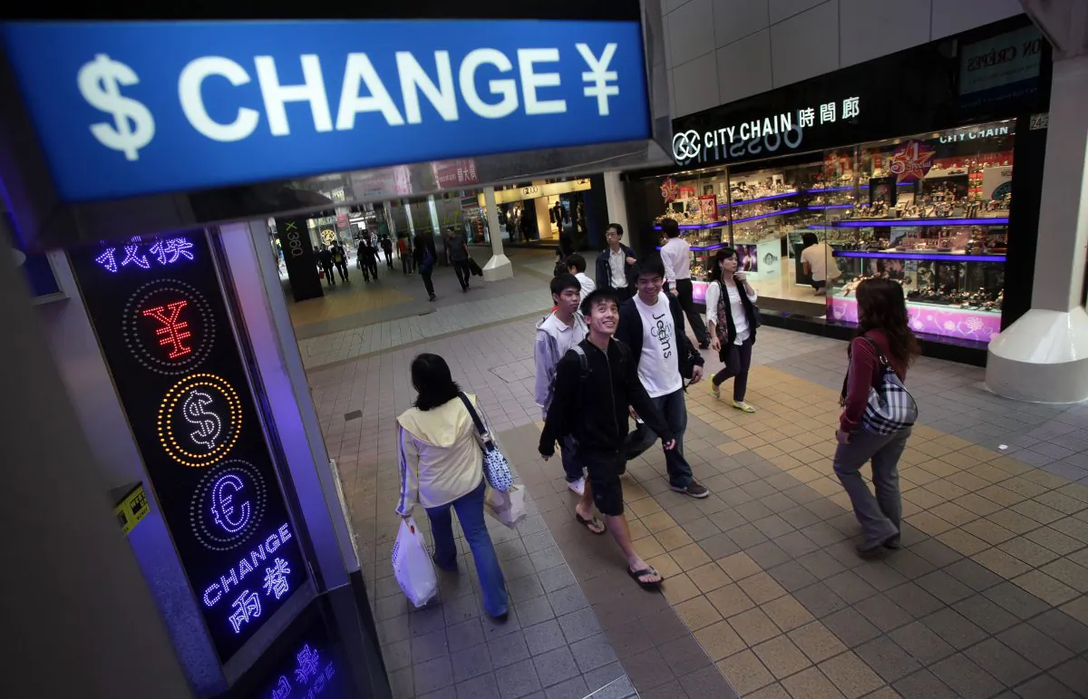 People walk past a currency exchange shop in the Causeway Bay area of Hong Kong on April 28, 2010. (Ed Jones/AFP/Getty Images)