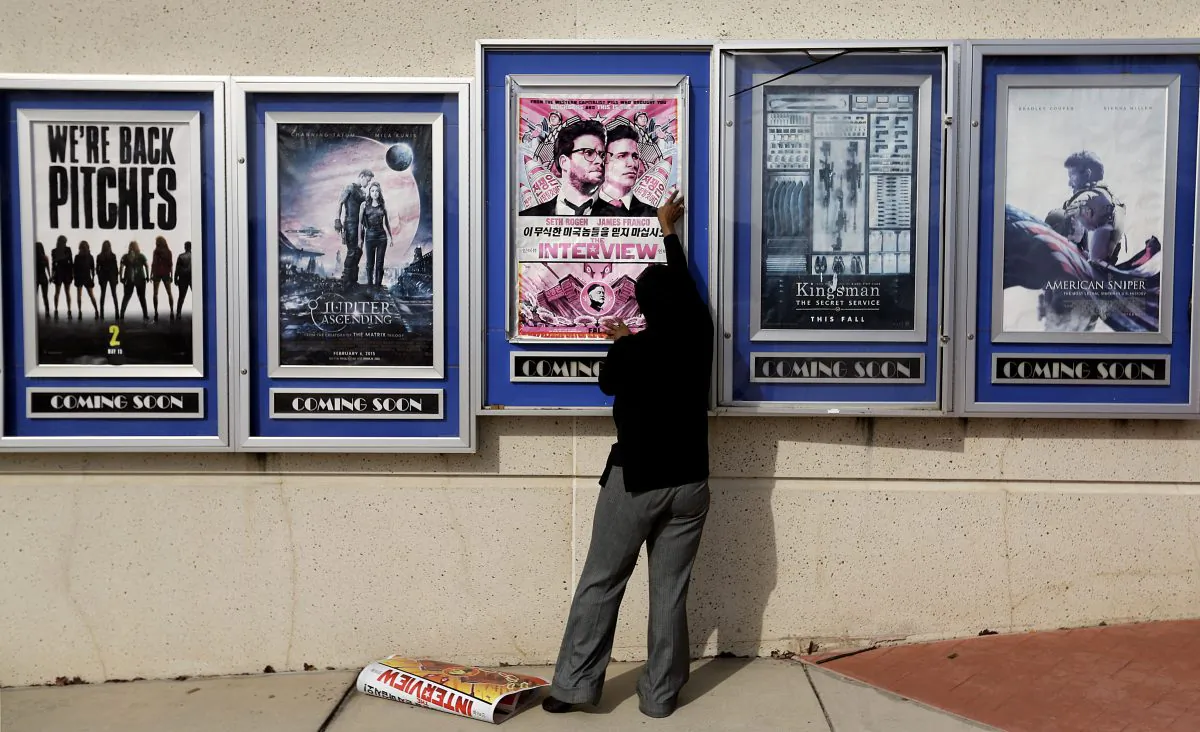 A poster for the movie "The Interview" is taken down by a worker after being pulled from a display case at a Carmike Cinemas movie theater in Atlanta on Dec. 17. (AP Photo/David Goldman)