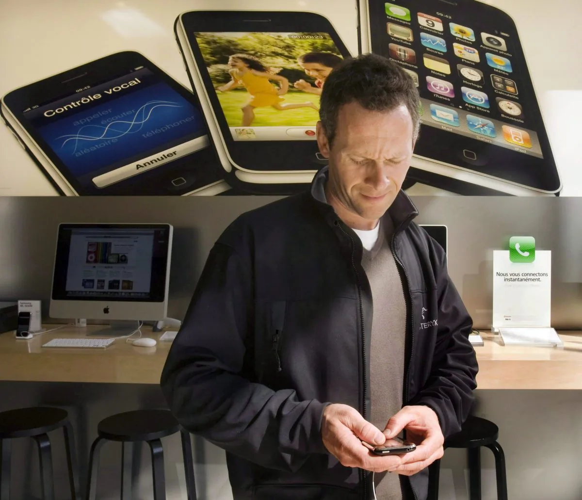Bruno Verner checks out an iPhone at the Apple store on Oct. 6, 2009, in Montreal. With the passage of Bill C-43, Canada's giant telecoms can now be fined for mistreating customers and breaking the telecommunications act, a move welcomed by open Internet advocates. (The Canadian Press/Ryan Remiorz)