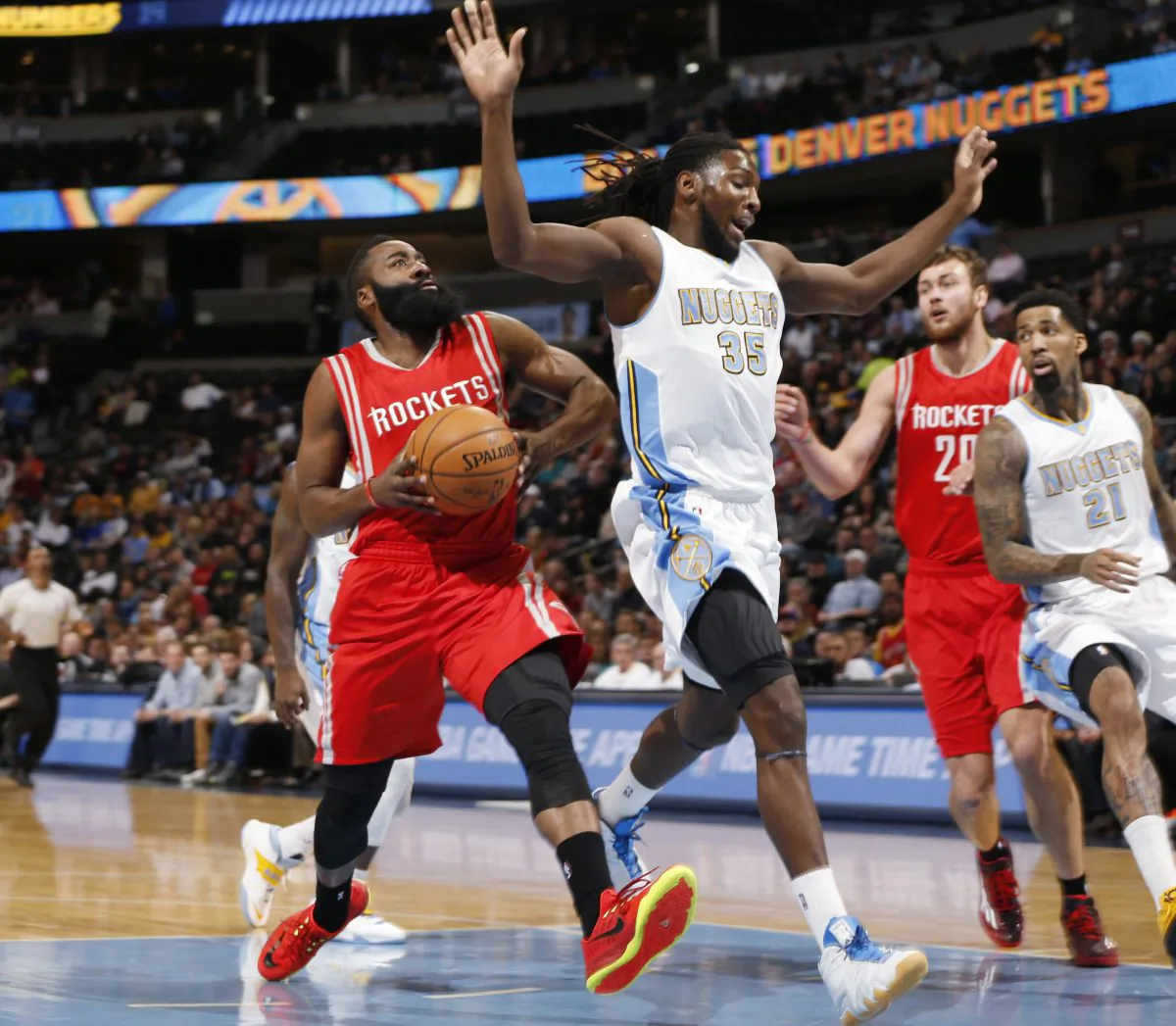 From left, Houston Rockets guard James Harden drives for a shot past Denver Nuggets forward Kenneth Faried as Rockets forward Donatas Motiejunas, of Lithuania, and Nuggets forward Wilson Chandler watch during the first quarter of an NBA basketball game on Wednesday, Dec. 17, 2014, in Denver. (AP Photo/David Zalubowski)