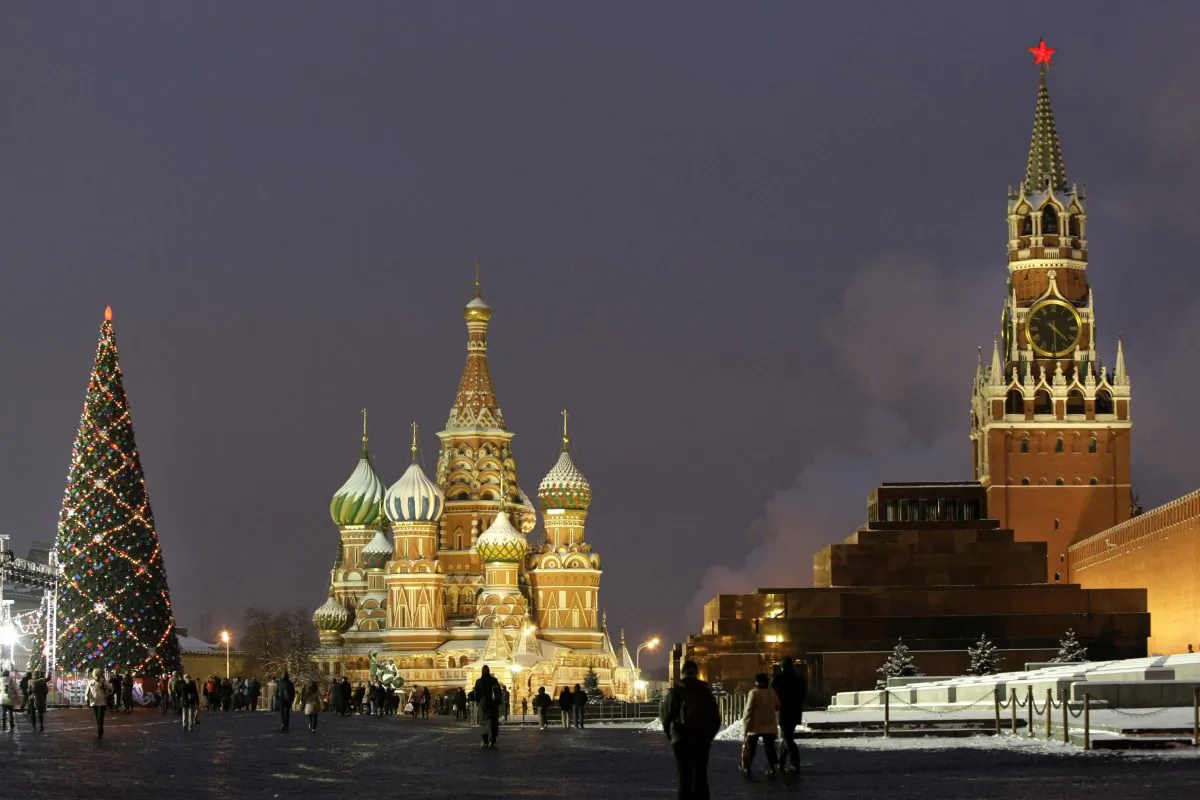 In this Thursday, Dec. 10, 2009 file photo people walk past a huge Christmas tree installed in Red Square, with St. Basil Cathedral, center, the Kremlin's Spassky Tower, right back, and Lenin Mausoleum, right, in Moscow, Russia. (AP Photo/Misha Japaridze)