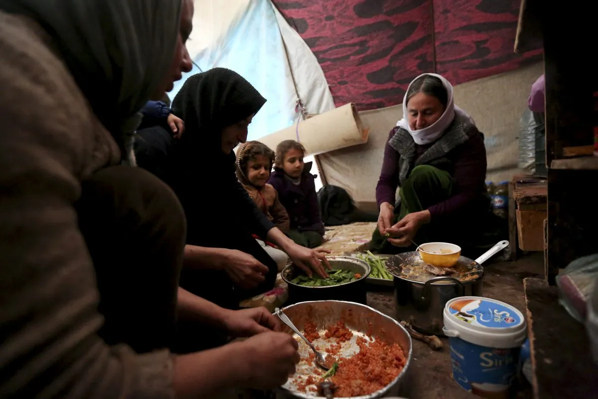 Yazidis displaced by Islamic State group militants share a meal as they take shelter in a partially constructed building in Dohuk, northern Iraq, on Dec. 10, 2014. In August, the militant group captured the northern Iraqi town of Sinjar, near the Syrian border, sending tens of thousands of Yazidis fleeing for their lives. Months later, many from the minority religious sect are living in harsh conditions without electricity, heating or safe drinking water. (AP Photo/Seivan Selim)