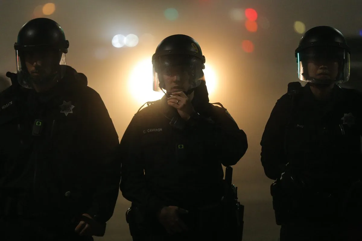 Police officers wearing body cameras form a line in East Oakland on the second night of protests for Eric Garner in Oakland, Calif., on Dec. 4. (Elijah Nouvelage/Getty Images)