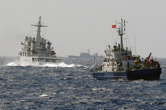 A China Coast Guard ship (L) blocks the way of a Vietnam Coast Guard ship on May 14, near to the site of a Chinese drilling oil rig (R, background) being installed at the disputed water in the South China Sea off Vietnam's central coast. (Hoang Dinh Nam/AFP/Getty Images)