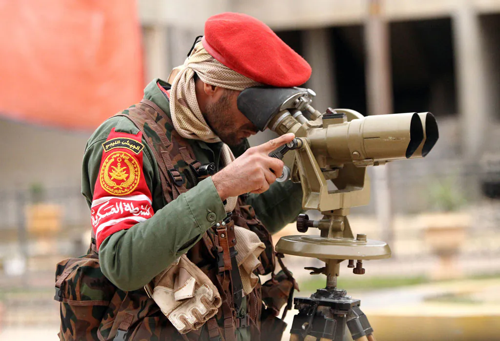A member of the Libyan military police looks through binoculars as they fight alongside troops loyal to Khalifa Haftar, a retired general and former chief of staff for Moamer Kadhafi, in clashes with Islamist gunmen in the eastern Libyan city of Benghazi on Dec. 16, 2014. (Abdullah Doma/AFP/Getty Images)