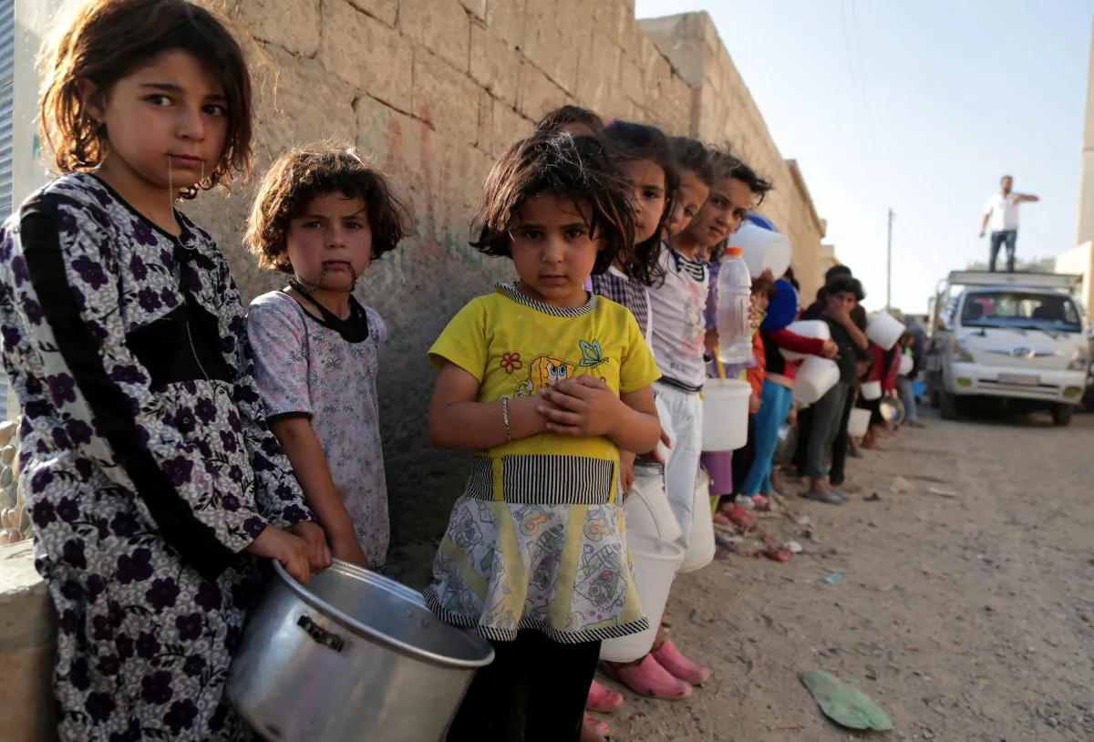 Syrian children wait in line to collect a free Iftar meal in the northern city of Raqqa during the Muslim holy month of Ramadan on July 14, 2013. (Mezar Matar/AFP/Getty Images)
