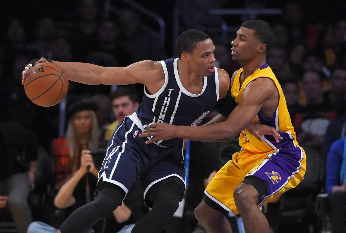 Oklahoma City Thunder guard Russell Westbrook, left, tries to drive by Los Angeles Lakers guard Ronnie Price during the first half of an NBA basketball game, Friday, Dec. 19, 2014, in Los Angeles. (AP Photo/Mark J. Terrill)