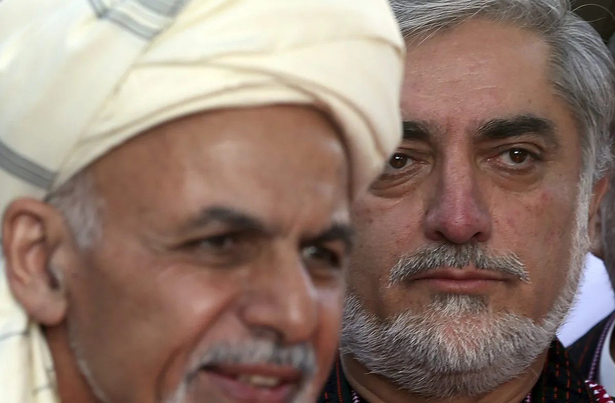 Afghanistan's Chief Executive Abdullah Abdullah, right, listens as President Ashraf Ghani speaks during the Eid al-Adha (Eid-e Qurban in local language) prayer ceremony at the presidential palace in Kabul, Afghanistan, Oct. 4, 2014. (AP Photo/Massoud Hossaini)