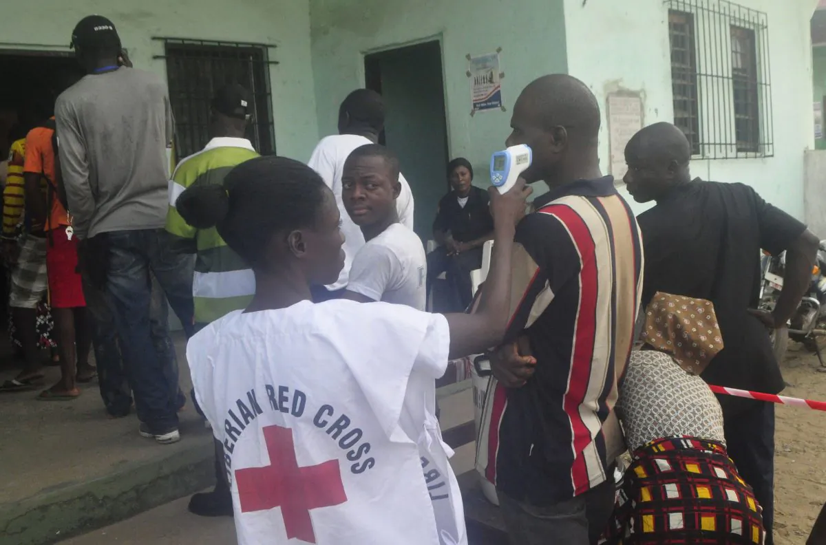 A Liberian red cross official takes the temperature of a man before casting his vote, during the senate election in Monrovia, Liberia. Saturday, Dec. 20, 2014. Health workers manned polling stations across Liberia on Saturday as voters cast their ballots in a twice-delayed Senate vote that has been criticized for its potential to spread the deadly Ebola disease. (AP Photo/Abbas Dulleh)
