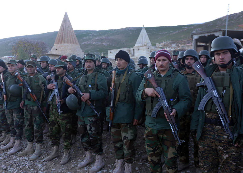 Iraqi Kurdish Peshmerga fighters gather in Sinjar, west of the northern Iraqi city of Mosul on Dec. 21, 2014, after an operation which broke the second Islamic State jihadist group (IS) siege of Mount Sinjar this year. The operation threatens the links between the city of Mosul, the main IS stronghold in Iraq, and territory the militant group controls in neighbouring Syria. (Safin Hamed/AFP/Getty Images)