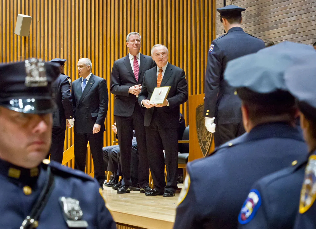 Detectives union president Michael Palladino (3rd L) joins Mayor Bill de Blasio (C) during a promotions ceremony for detectives in New York on Dec. 19, 2014. Even as New York’s police department takes heat for its tactics in the outrage over the Eric Garner chokehold case, year-end crime statistics show two clear trends: low-level arrests are holding steady and overall crime continues to fall. (AP Photo/Bebeto Matthews)