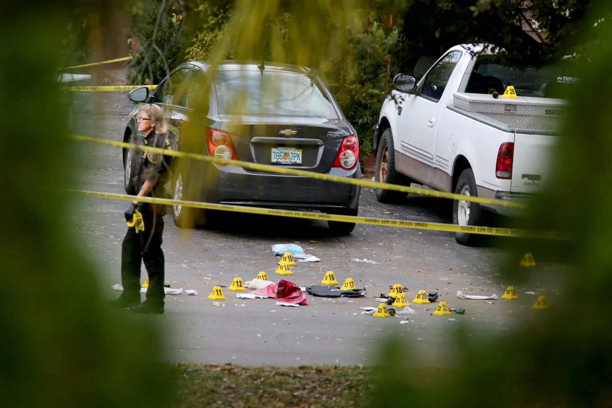A forensic science investigator with the Pinellas County Sheriff's Office investigates the scene where 45-year-old Tarpon Springs police officer Charles Kondek was shot and killed, Sunday, Dec. 21, 2014, in Tarpon Springs, Fla. (AP Photo/The Tampa Bay Times, Douglas R. Clifford) 