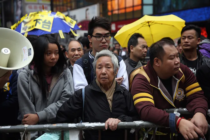 Protesters watch from outside the pro-democracy protest site as police cleared the area in the Causeway Bay district of Hong Kong on December 15, 2014. (Isaac Lawrence/AFP/Getty Images)