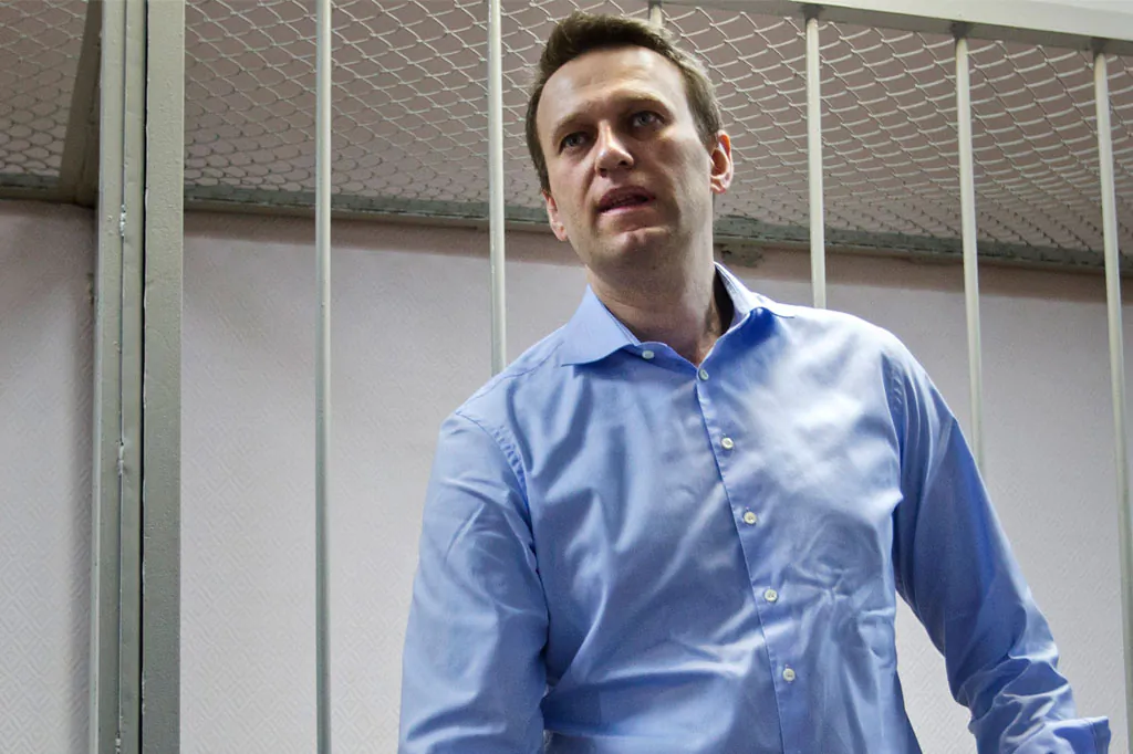 Russian opposition activist and anti-corruption crusader Alexei Navalny, 38, waits for a start of a trial in a court room in Moscow, Russia, Friday, Dec. 19, 2014. Russian prosecutors on Friday asked a court to sentence President Vladimir Putin's chief foe to 10 years in prison, but the defiant opposition leader vowed to keep up his fight against the Kremlin regime. (AP Photo/Pavel Golovkin)