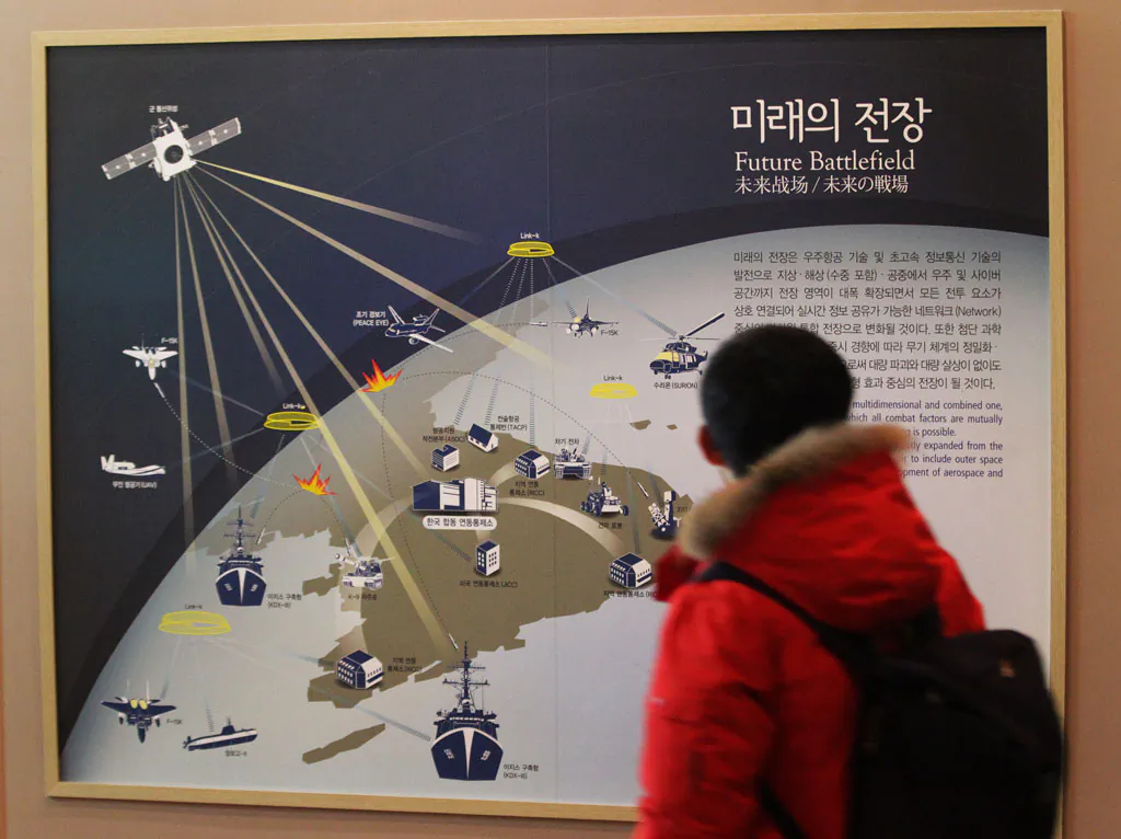 A South Korean student looks at a picture, which shows how the cyber warfare is going to be waged in the future in the Korean Peninsula if Korean War takes place, at Korea War Memorial Museum in Seoul, South Korea, Tuesday, Dec. 23, 2014. An hours-long Internet outage in one of the world’s least-wired countries was probably more inconvenient to foreigners than to North Korean residents, most of whom have never gone online. South Koreans, who are banned by national security law from accessing North Korean websites, the outage made little difference in their lives. (AP Photo/Ahn Young-joon)