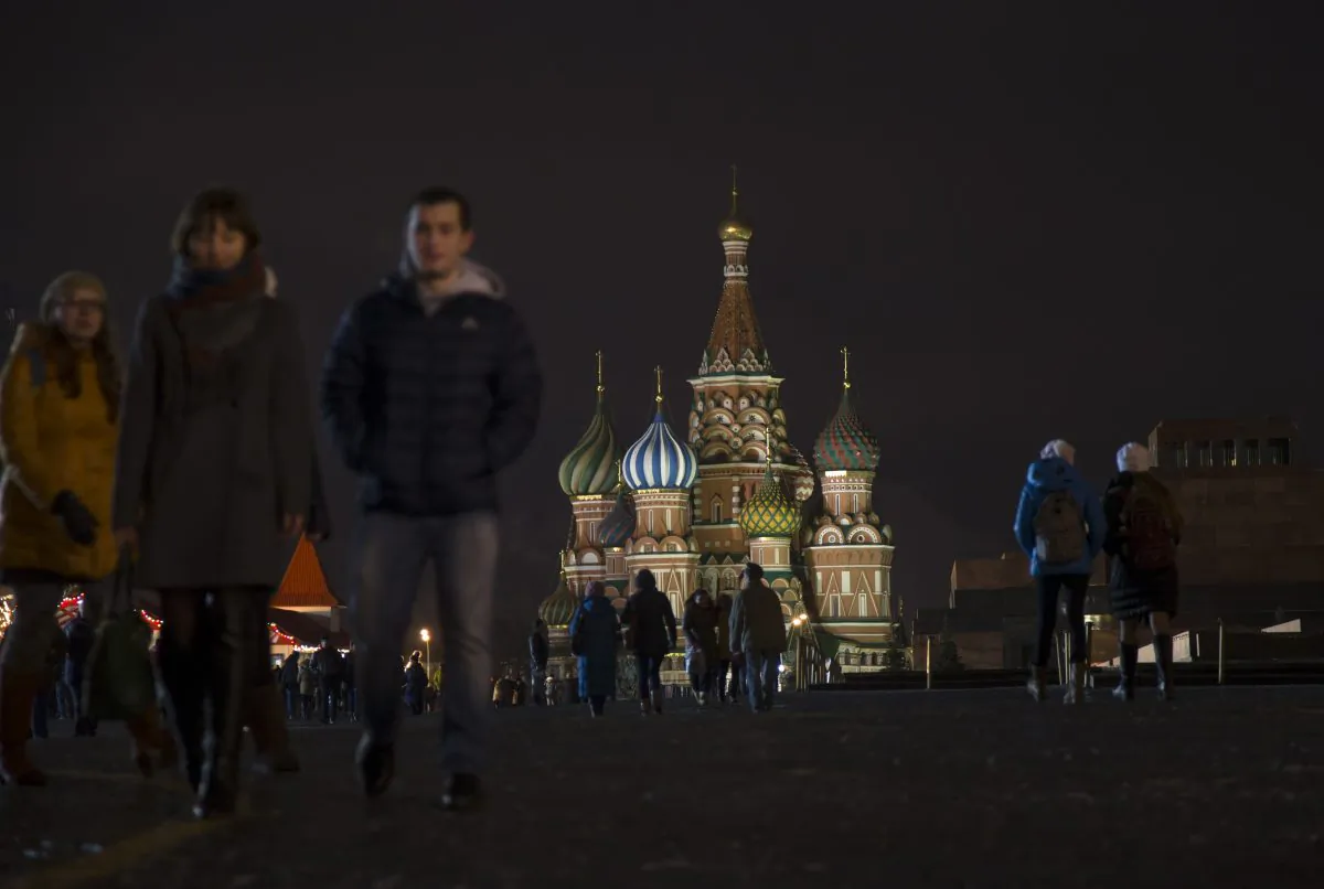 People walk through Moscow's Red Square with St. Basil Cathedral is in the background, Russia, Tuesday, Dec. 23, 2014. (AP Photo/Alexander Zemlianichenko)