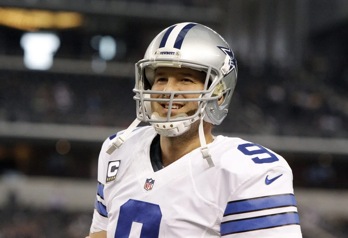 Dallas Cowboys quarterback Tony Romo (9) smiles as he steps onto the field for warmups before an NFL football game against the Indianapolis Colts, Sunday, Dec. 21, 2014, in Arlington, Texas. (AP Photo/Brandon Wade)
