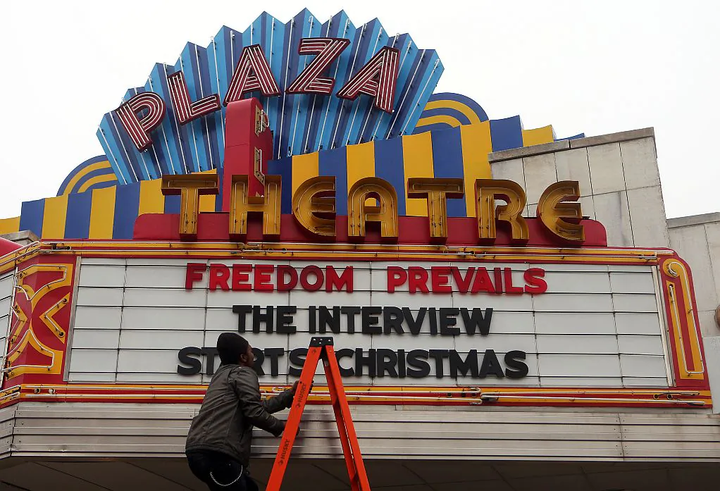 A man finishes hanging the marquis for “The Interview," at the Plaza Theatre in Atlanta, on Tuesday in which the theater will show on Christmas day. (AP Photo/Atlanta Journal-Constitution, Ben Gray)