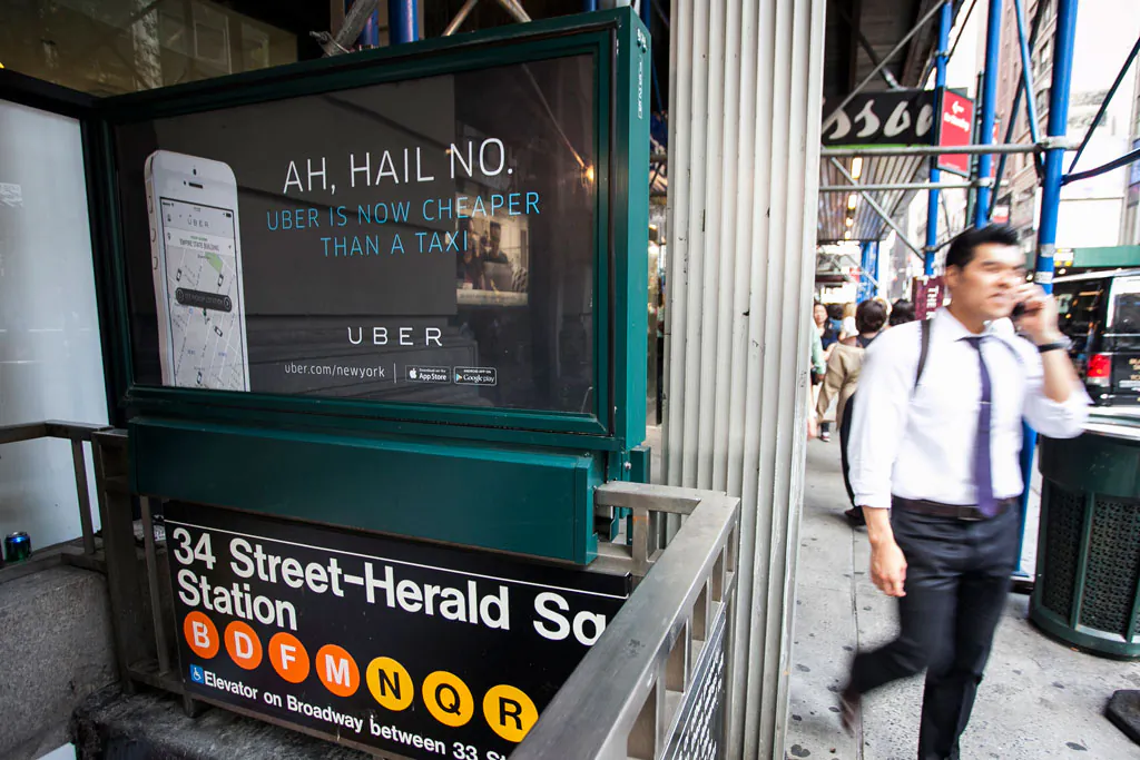 An Uber advertisement on top of the Herald Square subway entrance in Manhattan, N.Y., on Aug. 20, 2014. Uber announced a new $2 surcharge on taxi rides that went into effect Dec. 25. (Samira Bouaou/Epoch Times)