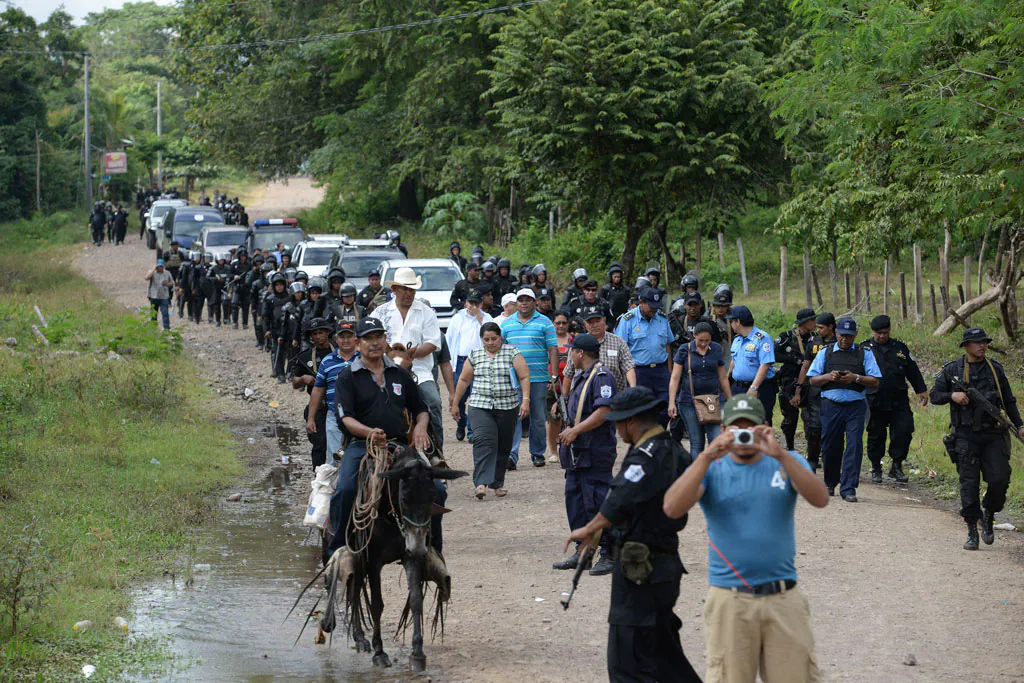 Riot police enter the town of El Tule, Nicaragua after they cleared a roadblock erected by residents, Wednesday, Dec. 24, 2014. National police special forces and soldiers fired tear gas and rubber bullets at demonstrators who had blocked the Pan American highway to protest against a proposed transoceanic canal. Thousands had maintained the roadblock since workers broke ground Monday for the $50 billion canal, which will require the expropriation of land. (AP Photo/Oscar Navarrete)