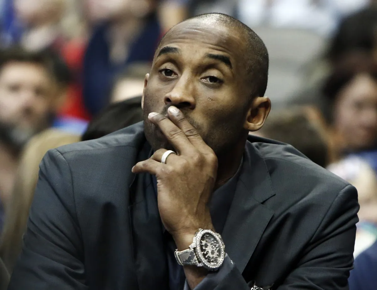 Los Angeles Lakers guard Kobe Bryant looks on from the bench in the first half of an NBA basketball game against the Dallas Mavericks, Friday, Dec. 26, 2014, in Dallas, Texas. Bryant was sitting out his third straight game to rest his sore body but could be back in the lineup when the Lakers return home for their next outing. (AP Photo/Brandon Wade)
