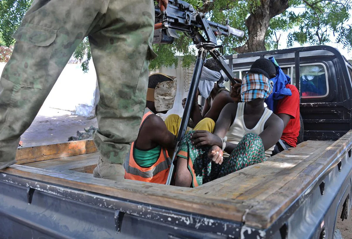 Four suspected Shebab fighters are detained by Somalian national soldiers following a gun battle in Mogadishu that left four other suspects dead on Dec. 26, 2014, a day after al-Shabab militants attacked the AMISOM force's heavily fortified headquarters in Somalia. The African Union force known as AMISOM said troops regained control of the base in Mogadishu after a gunfight that left five of the attackers dead while three others were captured. (Mohamed Abdiwahab/AFP/Getty Images)