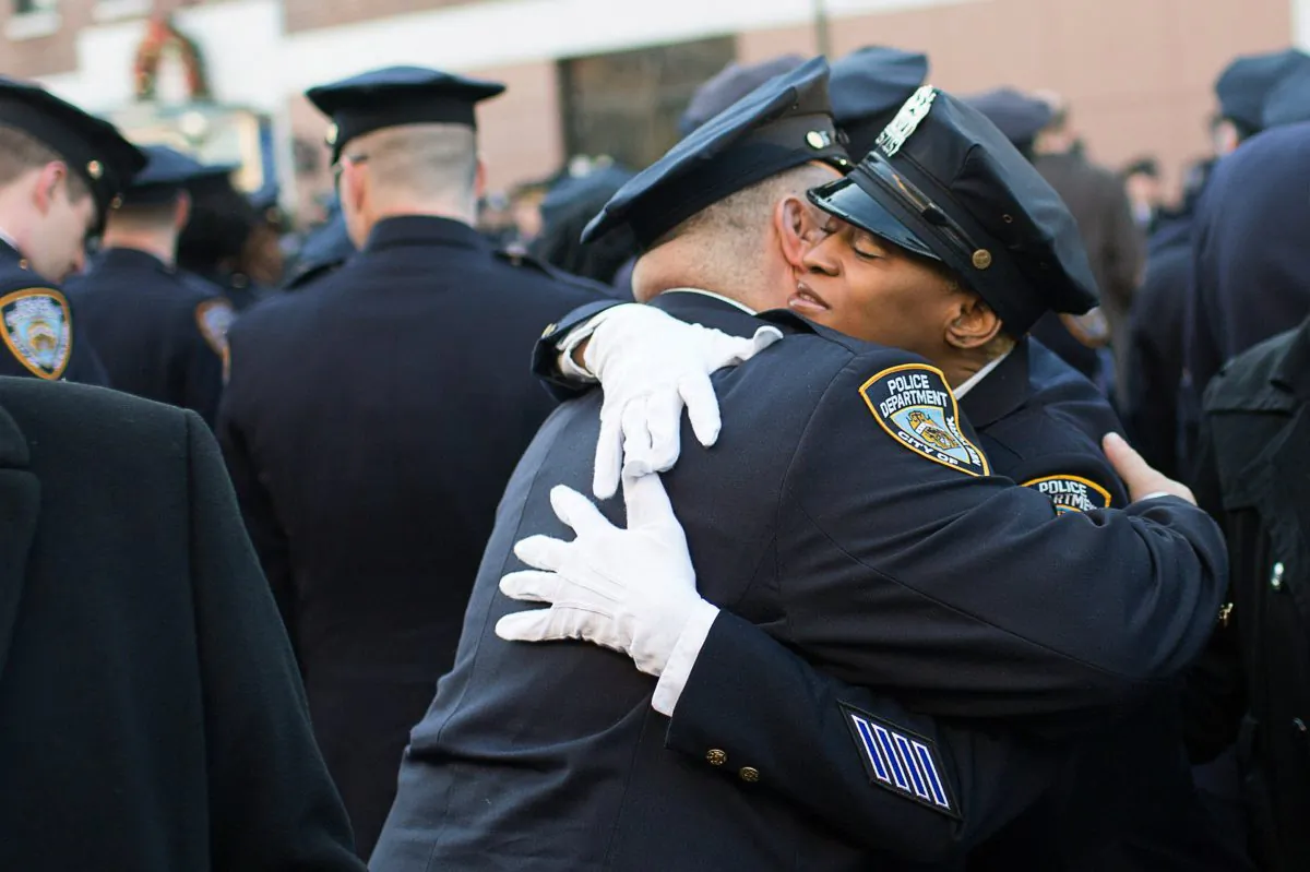 New York Police Department (NYPD) officers embrace before the funeral of slain NYPD officer Rafael Ramos at the Christ Tabernacle Church in New York City on Dec. 27, 2014. (Kevin Hagen/Getty Images)