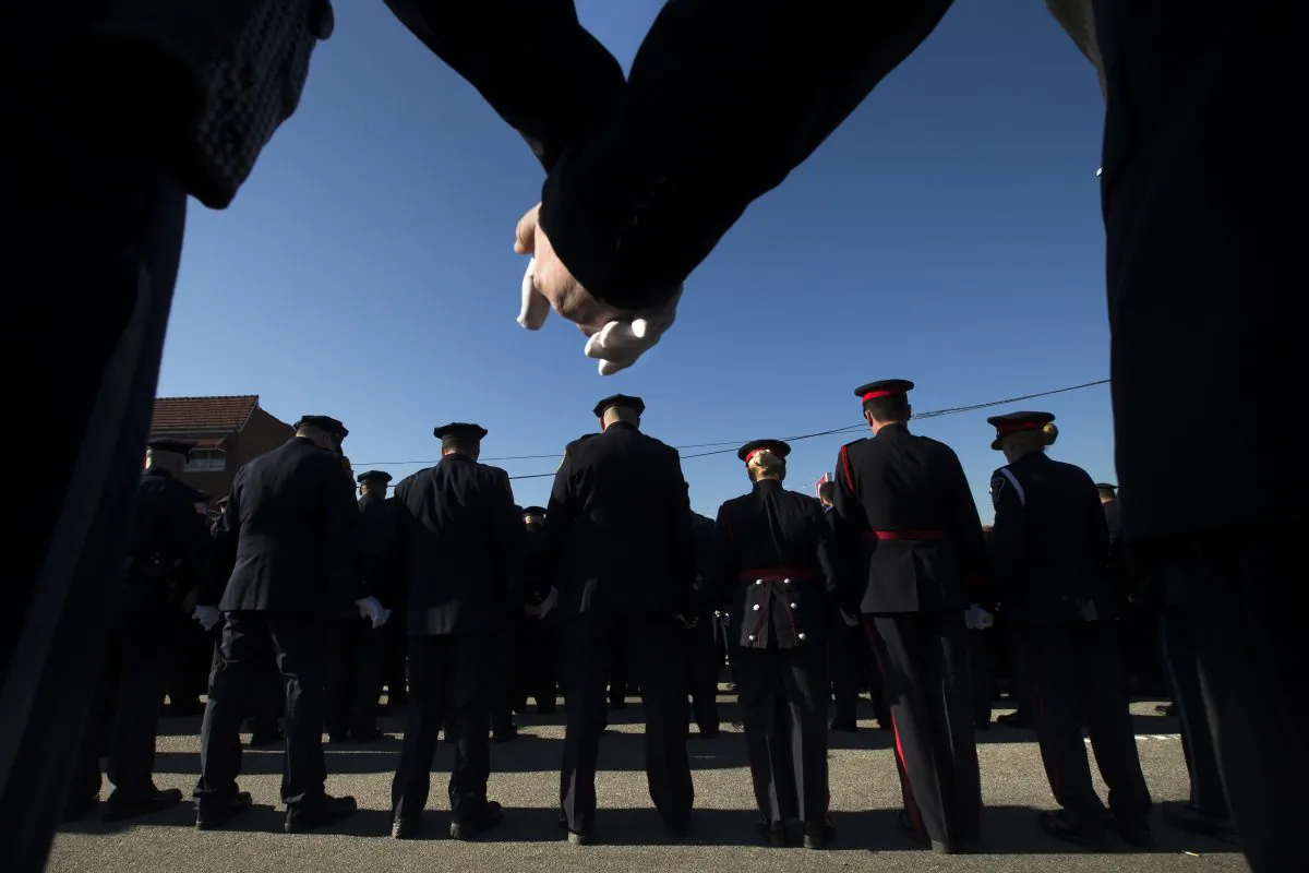 Police officers hold hands in prayer during the funeral service of New York City police officer Rafael Ramos in the Glendale section of Queens, Saturday, Dec. 27, 2014, in New York. Ramos and his partner, officer Wenjian Liu, were killed Dec. 20 as they sat in their patrol car on a Brooklyn street. The shooter, Ismaaiyl Brinsley, later killed himself. (AP Photo/John Minchillo)