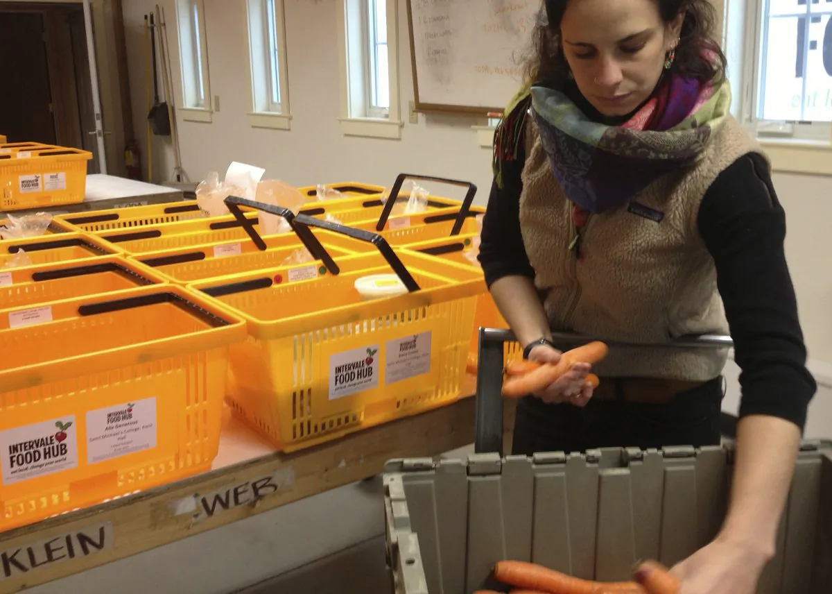 Sam Rothberg, packing house supervisor for the Intervale Food Hub in Burlington, Vt., packs carrots into weekly deliveries of food produced by area farmers, on Dec. 16, 2014. Food hubs around the country are getting more fresh, locally produced food out to consumers and giving farmers another avenue for expanding their sales. (AP Photo/Lisa Rathke)