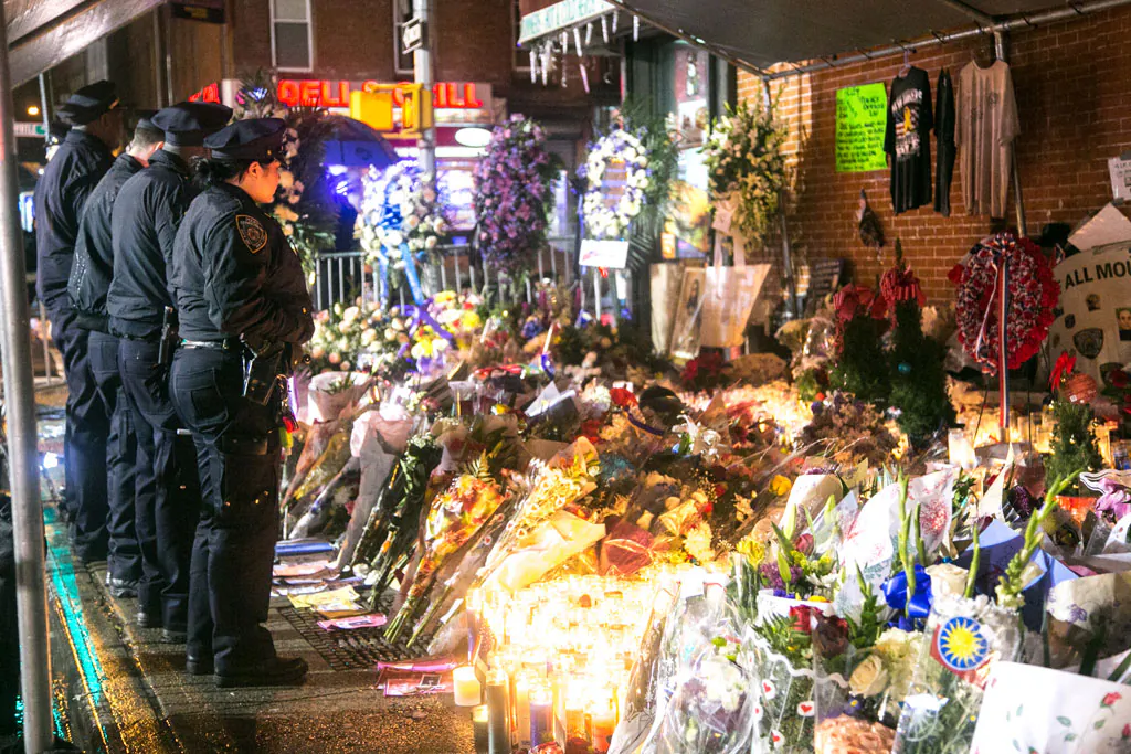 New York Police Department officers visit a makeshift memorial in Brooklyn, New York, on Dec. 24, for the officers who were murdered in their police car by an emotionally disturbed man. (Benjamin Chasteen/Epoch Times)