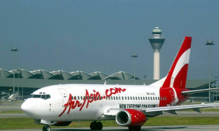 An aircraft of Malaysia's domestic airline, AirAsia, preparing for take-off as it passes the Kuala Lumpur International Airport control tower on Feb. 8, 2003. (Roslan Rahman/AFP/Getty Images)