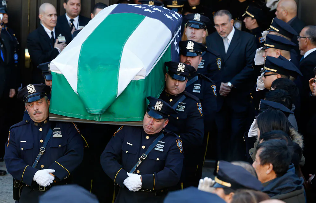 Pallbearers carry the casket of New York City police officer Rafael Ramos outside Christ Tabernacle Church in Glendale, Queens, New York, after the funeral for slain officer Rafael Ramos was held on Dec. 27, 2014. (AP Photo/Julio Cortez)