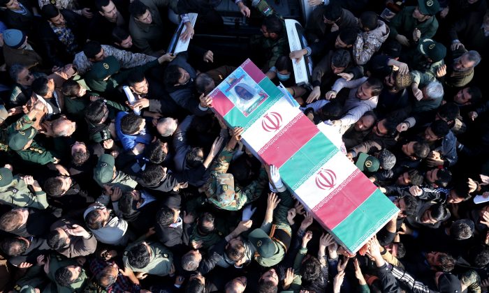 Iranian civilians and armed forces members carry the flag draped coffin of Brig. Gen. Hamid Taqavi, a senior Revolutionary Guard commander who was killed during a battle against the Islamic State extremist group in Iraq, in his funeral ceremony outside the Guard compound in Tehran, Iran, Monday, Dec. 29, 2014. The Guard said Sunday that Taqavi was "martyred while performing his advisory mission" in Samarra, a town north of Baghdad that is home to a major Shiite shrine. He is the highest ranking Iranian officer known to have been killed abroad since the Iran-Iraq war in the 1980s, in which he fought. (AP Photo/Ebrahim Noroozi)